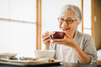 笑顔で食事をするシニア女性の画像