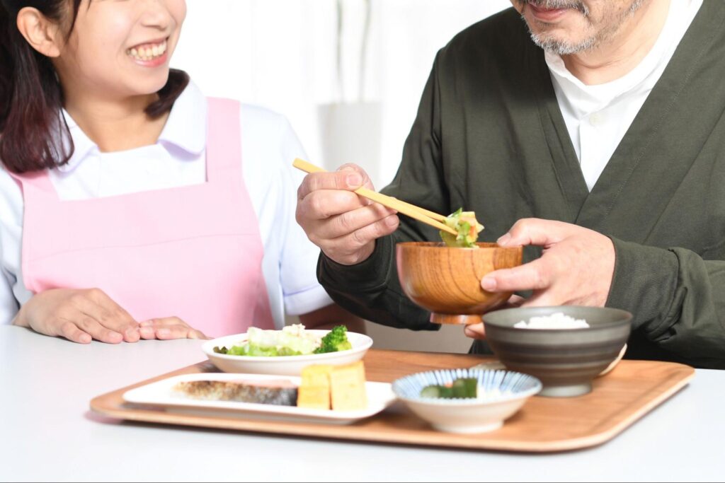嚥下訓練中のシニア男性とトレーナー女性の画像