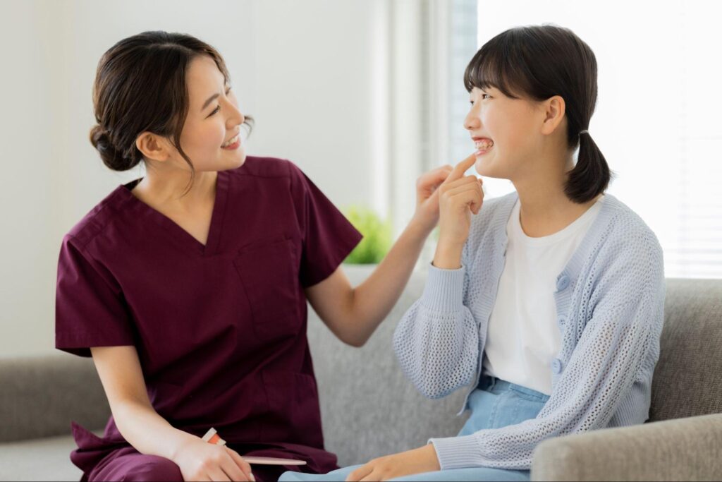 笑顔の若い女性患者と女性歯科医師
