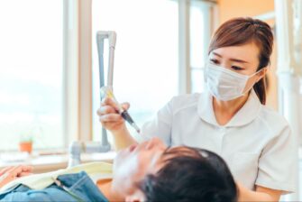 歯医者で治療中の患者と医療従事者