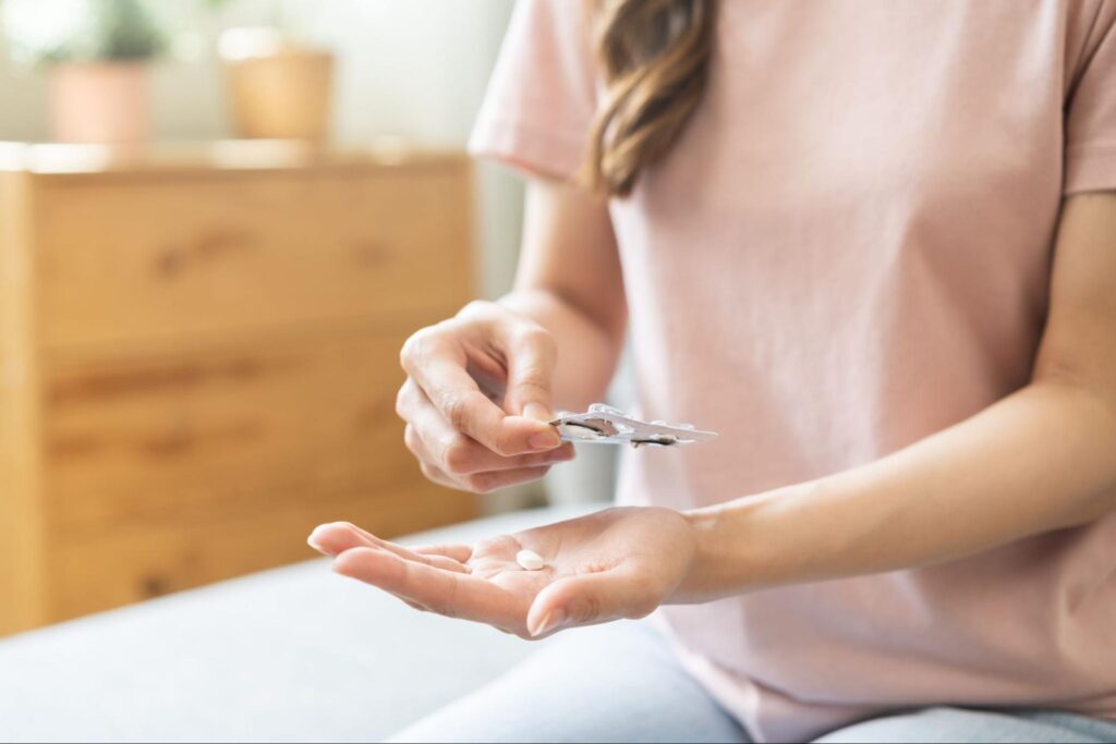 親知らずの抜歯の痛みを軽減するため痛み止めを飲む女性