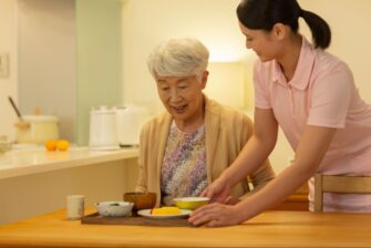 高齢女性に食事を提供する医療従事者の女性