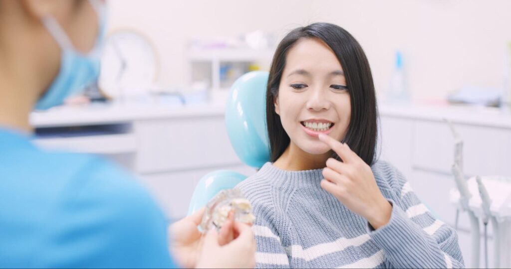 抜歯後にブリッジについて説明を受ける女性