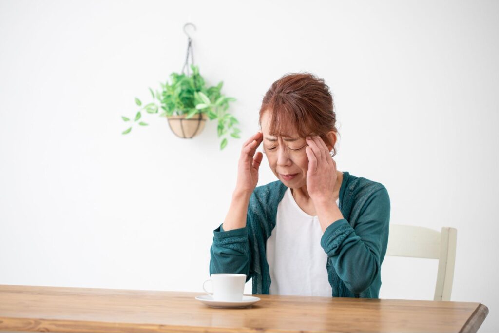 頭を抱える高齢女性