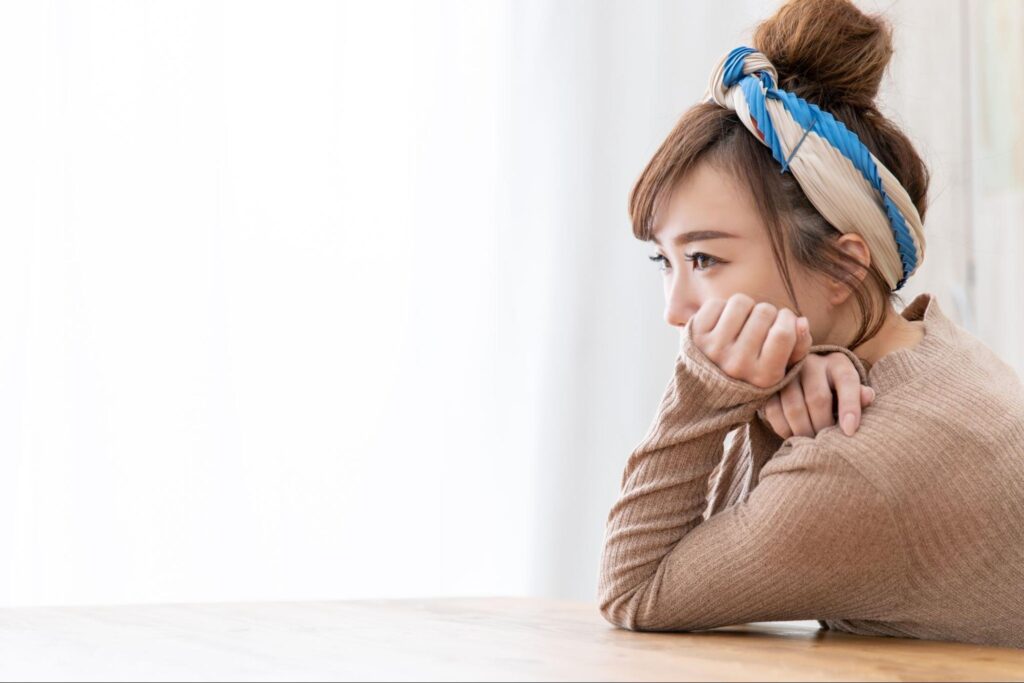 抜歯が不安で浮かない顔をする女性
