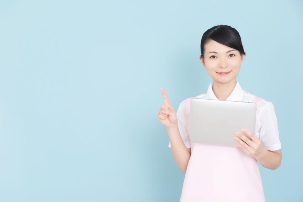 人差し指を立てる医療従事者の女性