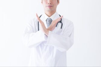 両手でバツを作る男性医師