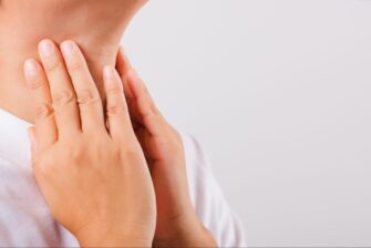 嚥下時に音が鳴る違和感を感じて喉を押さえている人の画像