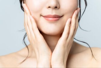 両手で頬を押さえる小顔の女性